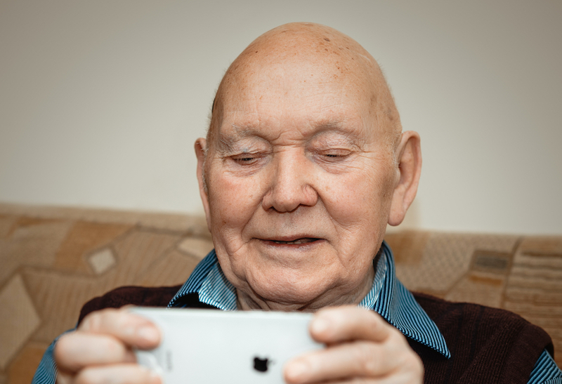 grandpa looking on his phone smiling