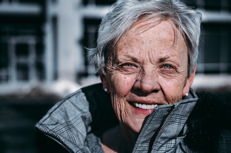 older woman smiling in a coat